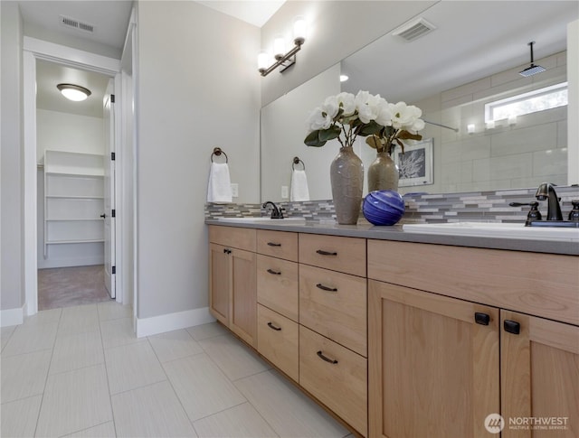 full bathroom with visible vents, backsplash, and a sink