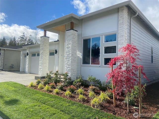 view of property exterior featuring concrete driveway and an attached garage