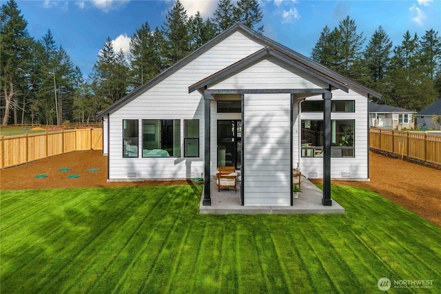 back of house featuring a patio, a yard, a fenced backyard, and crawl space