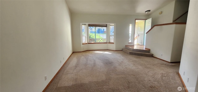 carpeted spare room with baseboards