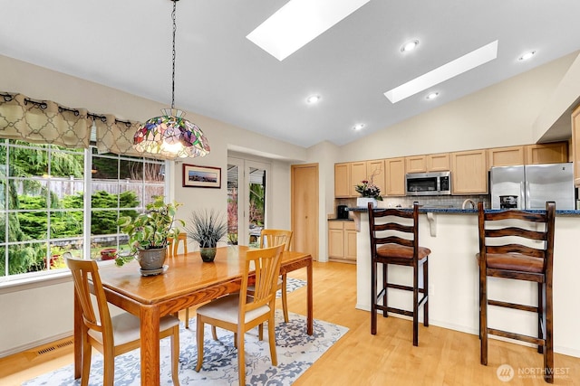 dining area with visible vents, high vaulted ceiling, a skylight, recessed lighting, and light wood-style floors