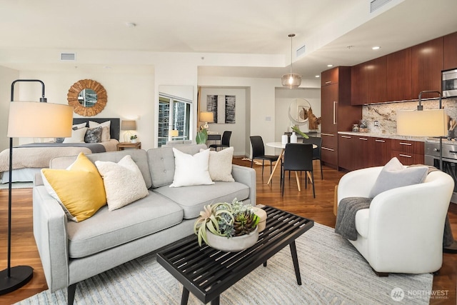 living area with recessed lighting, visible vents, and light wood-type flooring