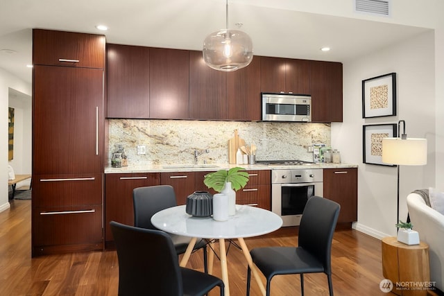 kitchen featuring a sink, wood finished floors, visible vents, and stainless steel appliances