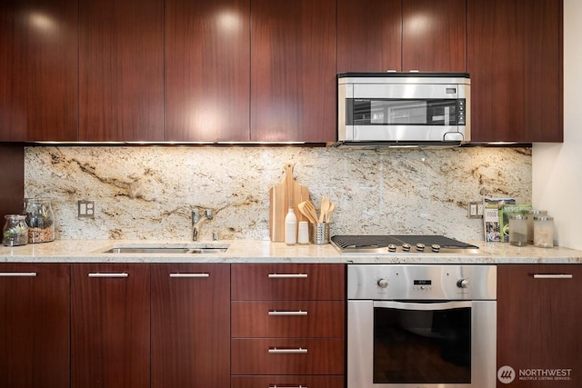 kitchen featuring a sink, light stone counters, modern cabinets, and stainless steel appliances