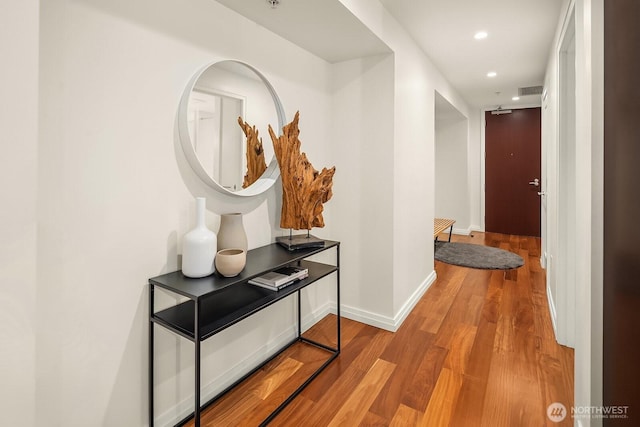 corridor featuring recessed lighting, light wood finished floors, and baseboards
