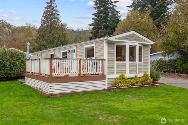 rear view of house with a lawn and a deck