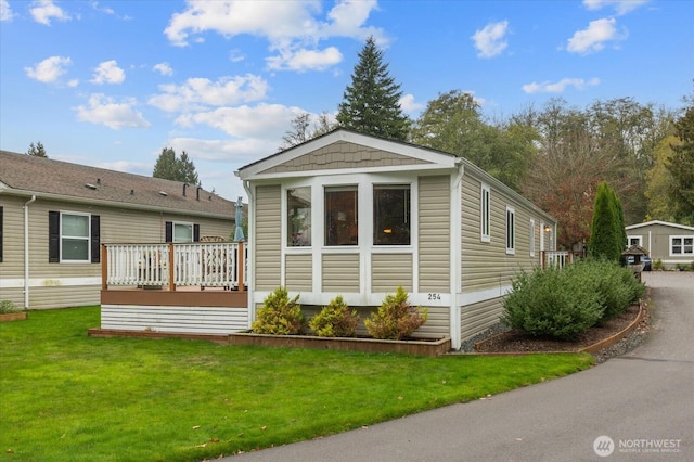 view of front of property featuring a deck and a front lawn