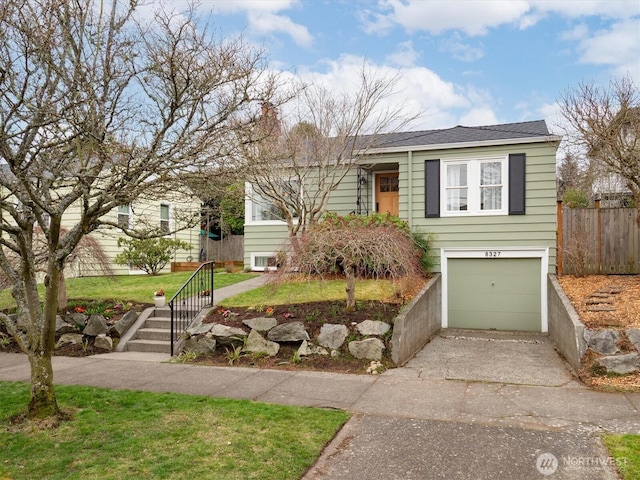 view of front of home with an attached garage, fence, and driveway