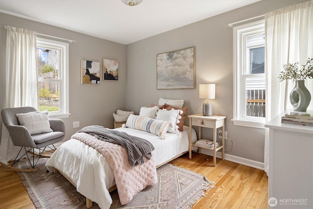 bedroom featuring baseboards and light wood finished floors