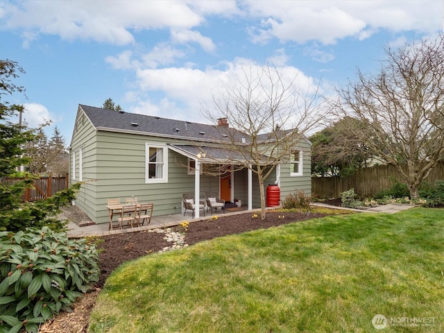 back of house featuring a patio area, a lawn, and fence