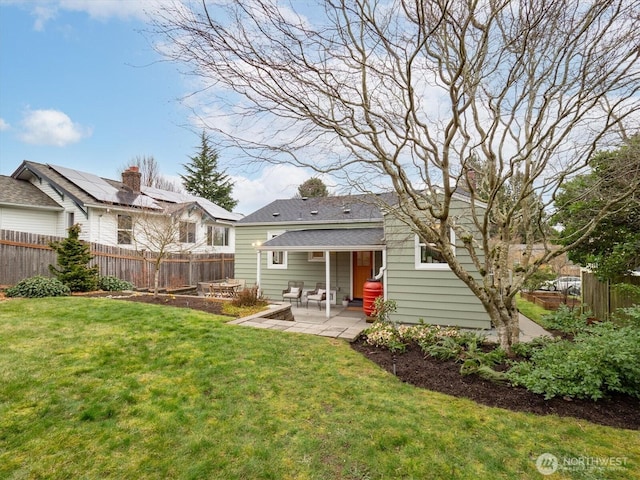 back of property with a lawn, a patio, and fence