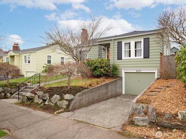 view of front of house featuring a garage, concrete driveway, a chimney, and fence