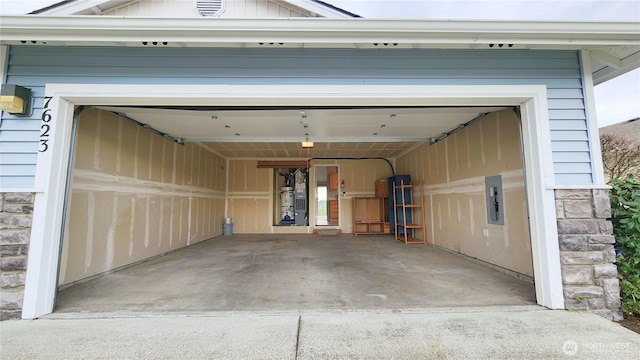 garage featuring electric panel and driveway