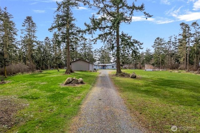 view of front of property with gravel driveway and a front lawn