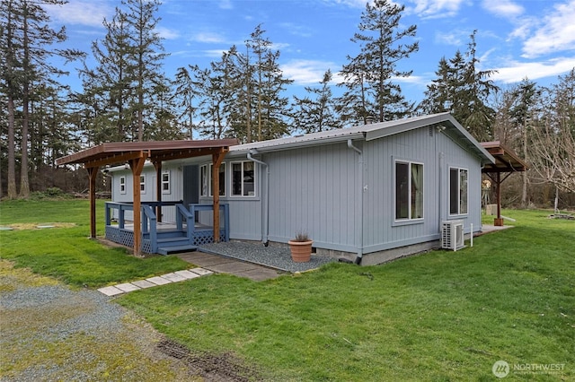 view of front of property with a front yard, central air condition unit, driveway, and metal roof