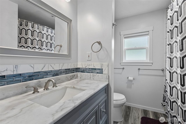 bathroom featuring vanity, a shower with curtain, wood finished floors, baseboards, and toilet