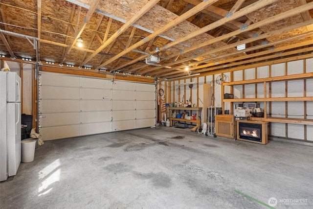 garage featuring a garage door opener and freestanding refrigerator