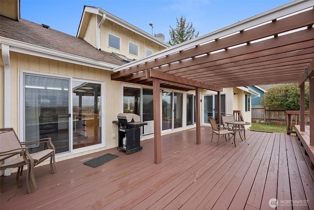 deck with grilling area, fence, and a pergola