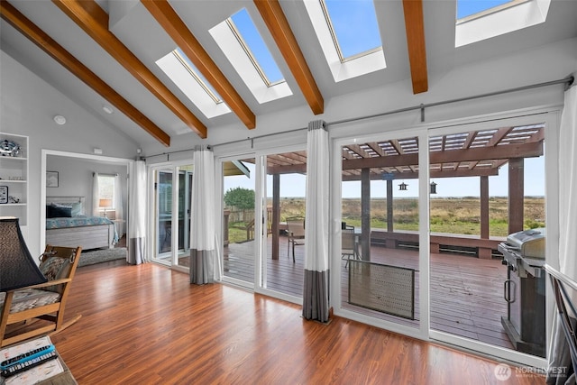 sunroom / solarium with vaulted ceiling with skylight and a fireplace