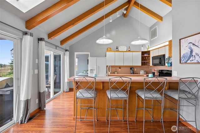 kitchen featuring visible vents, open shelves, black appliances, pendant lighting, and light wood-type flooring