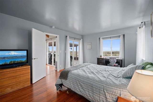 bedroom with wood finished floors and access to outside