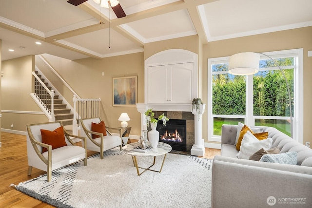 living room with light wood-type flooring, baseboards, coffered ceiling, beamed ceiling, and a fireplace