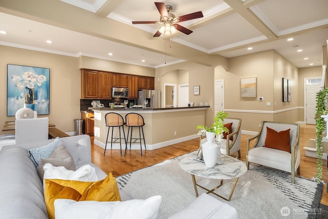 living area with light wood-type flooring, arched walkways, a ceiling fan, and recessed lighting