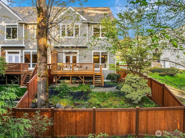 rear view of house with a wooden deck, a fenced backyard, and stairway