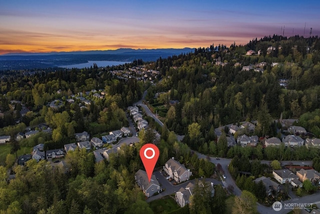 drone / aerial view featuring a residential view, a forest view, and a water view