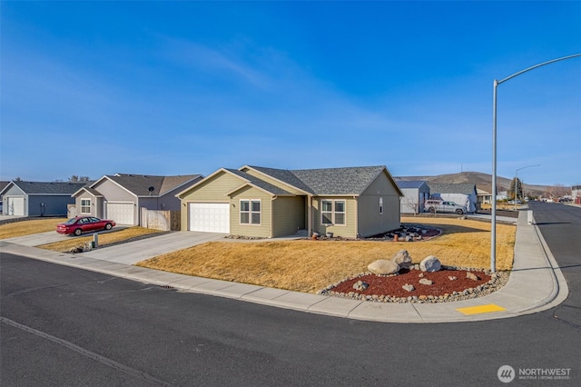 single story home with a residential view, an attached garage, driveway, and a front lawn