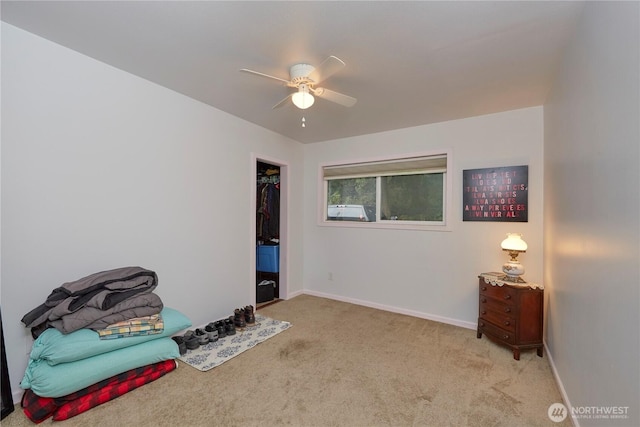 interior space featuring light colored carpet, baseboards, and ceiling fan