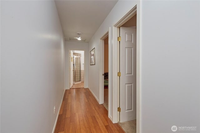 hall featuring baseboards and light wood-style floors