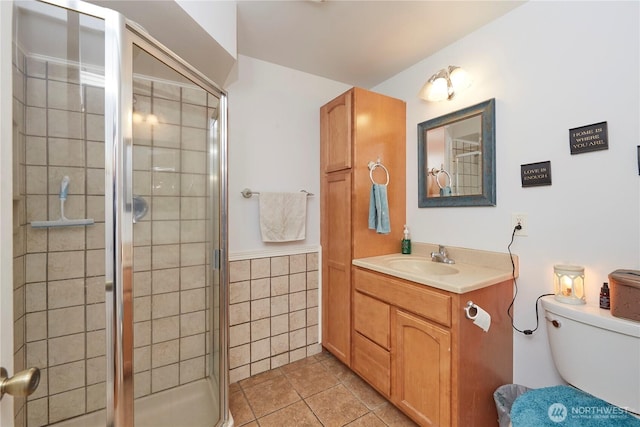 full bathroom with tile patterned flooring, tile walls, toilet, a stall shower, and vanity