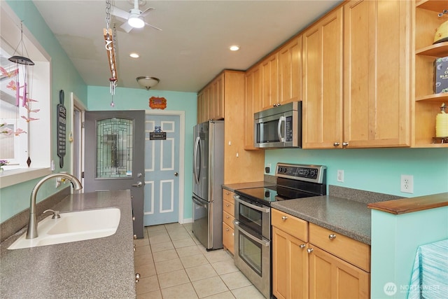 kitchen featuring a sink, open shelves, dark countertops, appliances with stainless steel finishes, and light tile patterned flooring