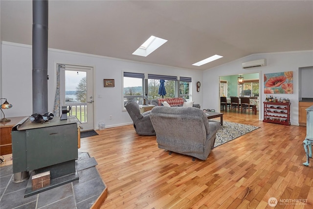 living area featuring lofted ceiling with skylight, a wood stove, light wood-style floors, and a wall mounted air conditioner