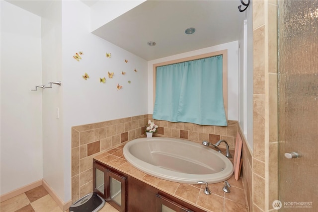 full bathroom featuring baseboards and a bath