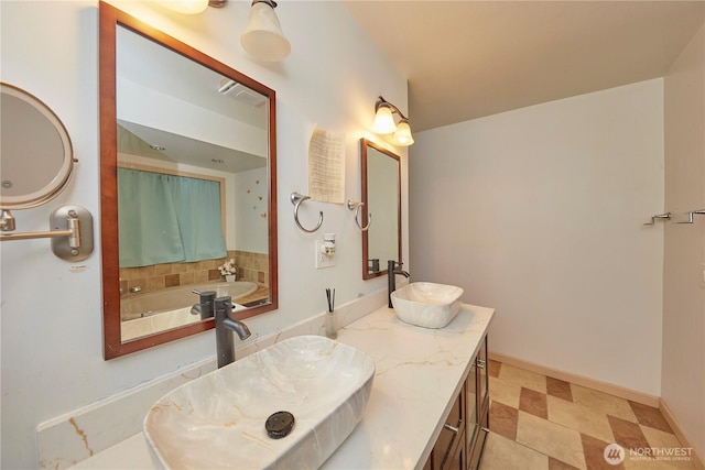 bathroom with double vanity, visible vents, baseboards, and a sink