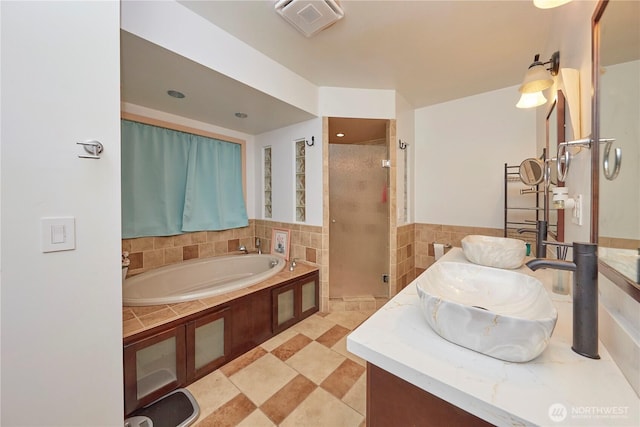 full bathroom with visible vents, vanity, a garden tub, and a shower stall