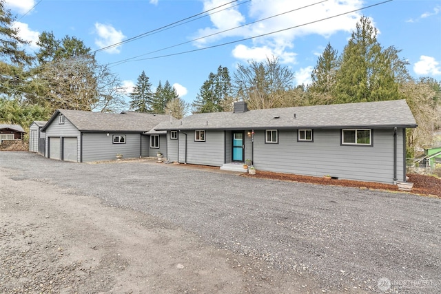 single story home with aphalt driveway, an attached garage, and a chimney