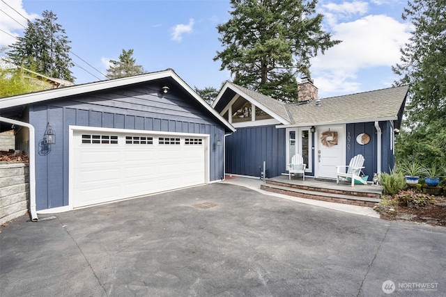 view of front of home with board and batten siding, a chimney, and a shingled roof