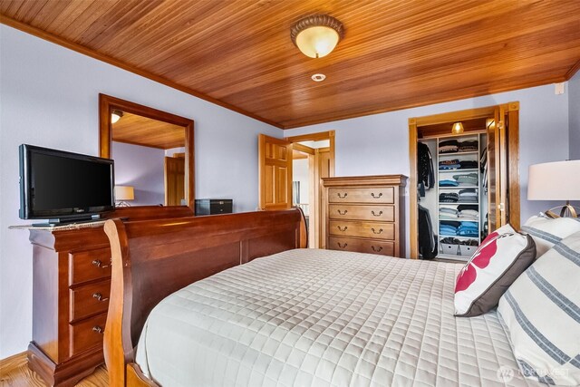 bedroom featuring a closet, wood ceiling, and crown molding