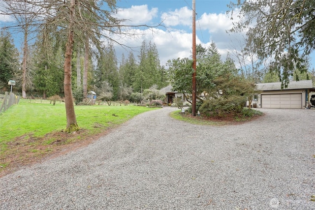 view of front of house with driveway, an attached garage, a front yard, and fence