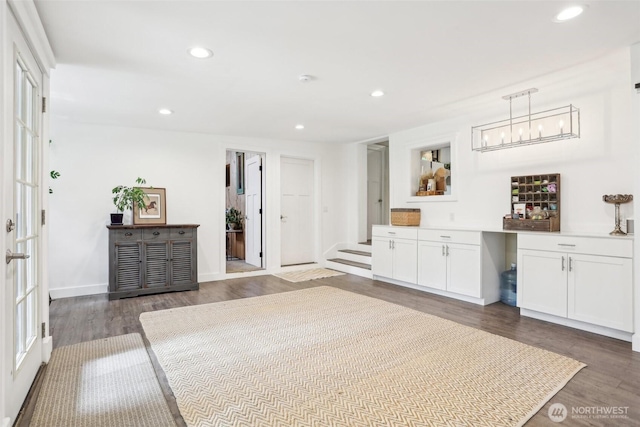 interior space featuring recessed lighting, baseboards, dark wood-style flooring, and hanging light fixtures