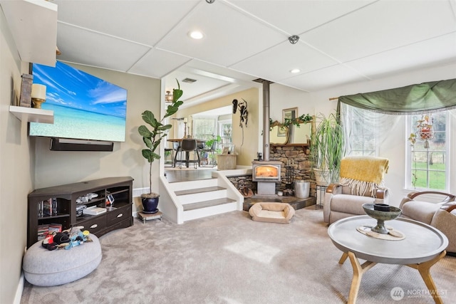 carpeted living room featuring recessed lighting and a wood stove