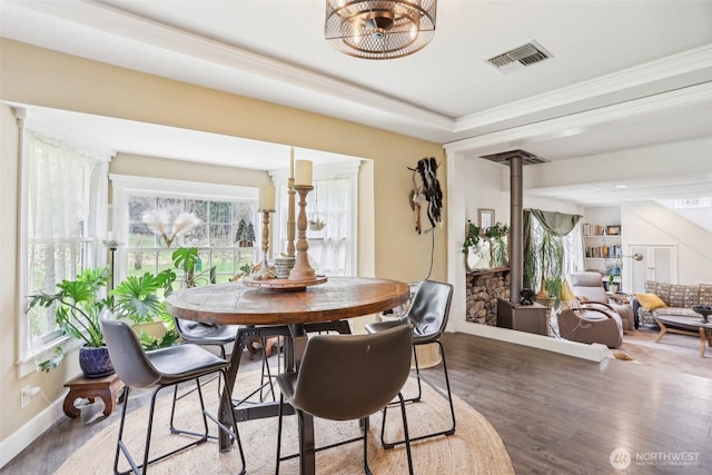 dining space featuring visible vents, ornamental molding, baseboards, and wood finished floors