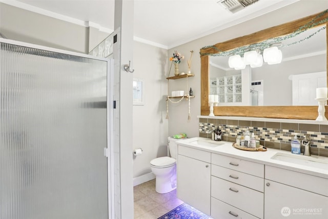 bathroom featuring decorative backsplash, a shower stall, visible vents, and a sink