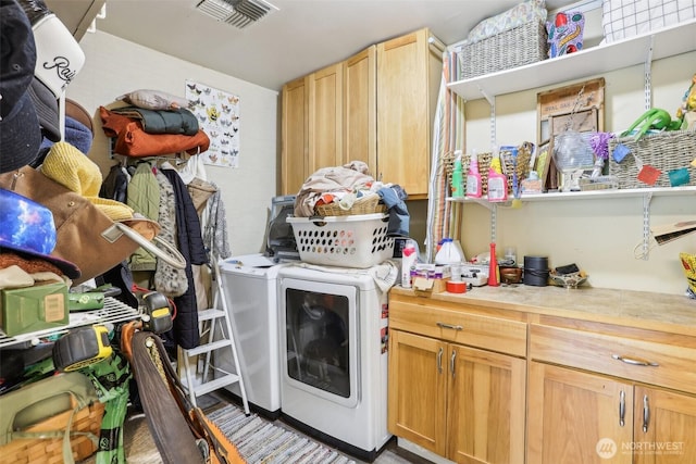 laundry room with washer and dryer, cabinet space, and visible vents