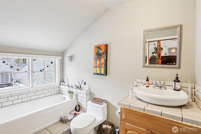 full bath featuring vanity, lofted ceiling, a tub, tile patterned flooring, and toilet