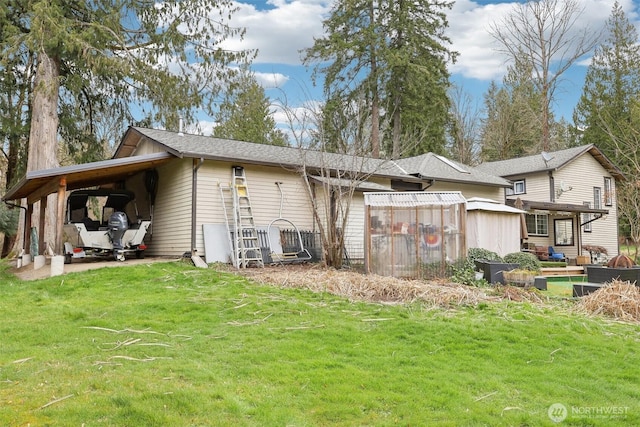 rear view of property with a yard and a carport