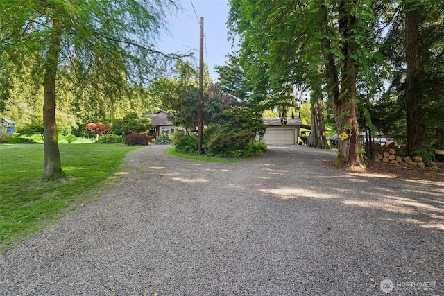 26821 NE 124th St, Duvall, WA 98019 - view of property hidden behind natural elements with gravel driveway, an attached garage, and a front yard